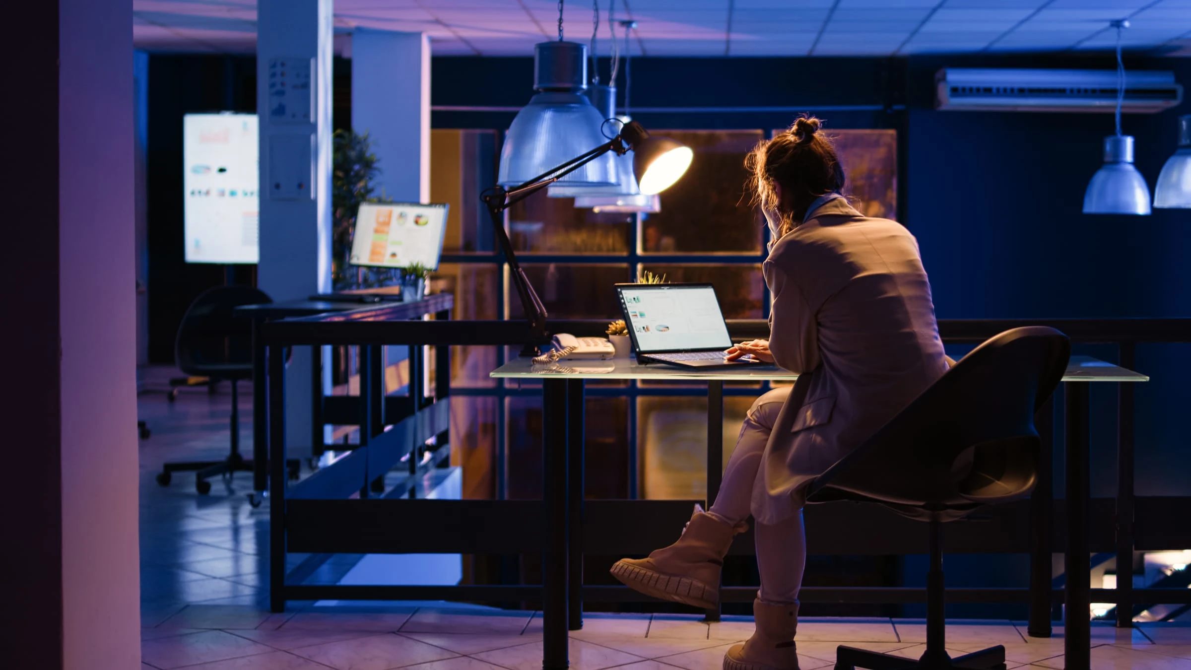 Profissional trabalha em um notebook em um escritório à noite